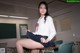 A woman sitting at a desk in a classroom.