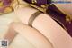 A close up of a woman's legs in stockings on a bed.