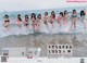 A group of girls in bikinis running into the ocean.