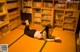 A woman laying on the floor in front of a book shelf.