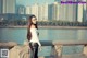 A woman in a white top and black leather pants posing for a picture.