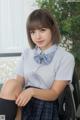 A woman in a school uniform sitting on a chair.