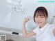 A woman standing in front of a whiteboard writing on it.