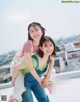 A couple of women standing next to each other on top of a roof.