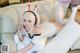 A woman laying on a white couch wearing bunny ears.