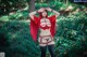 A woman dressed as a red riding hood in the woods.